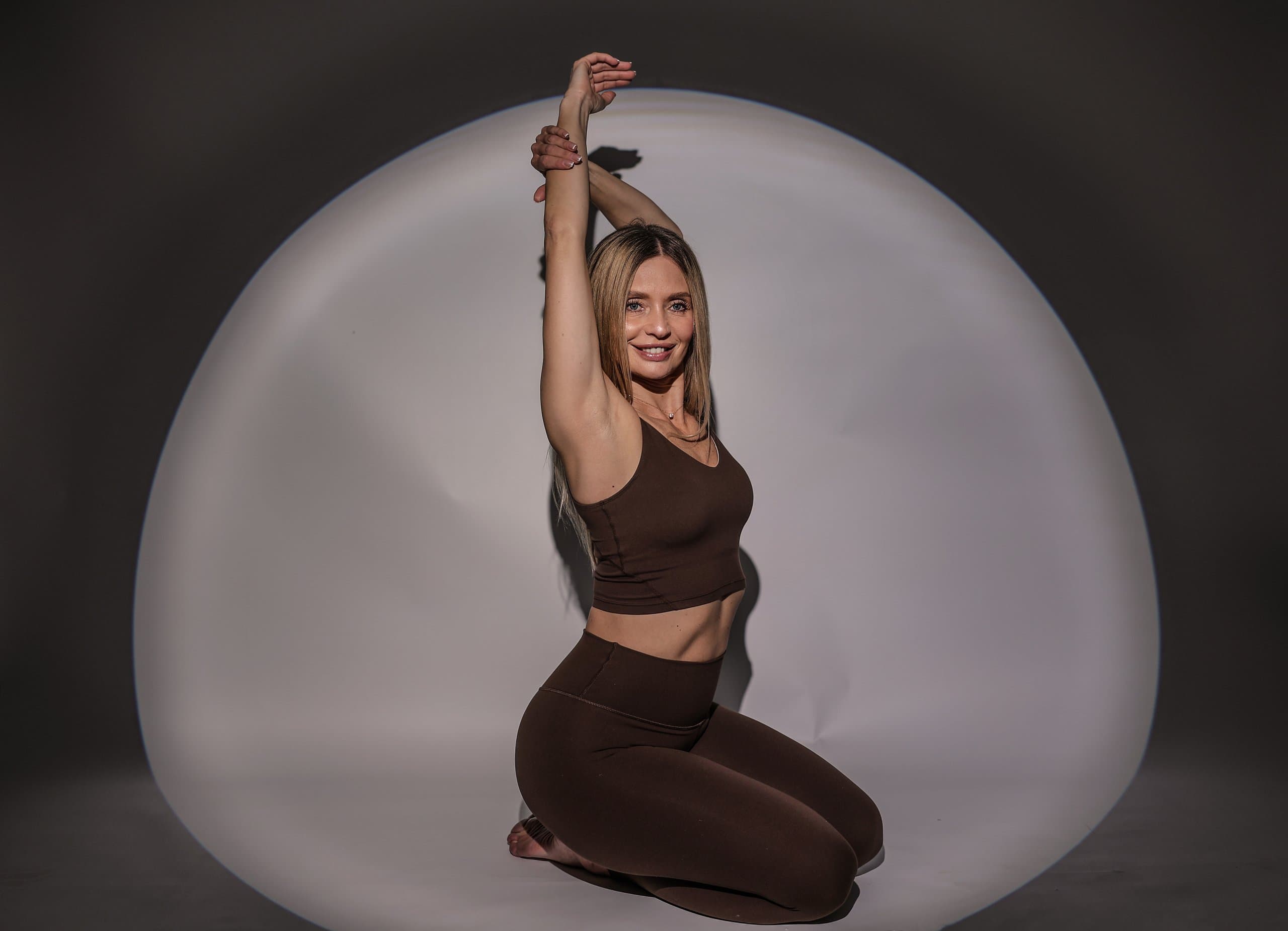 Vicky performing a Pilates stretch with arms raised